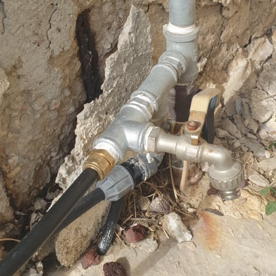 צינורות מתכת וברז מים מחוברים לקיר