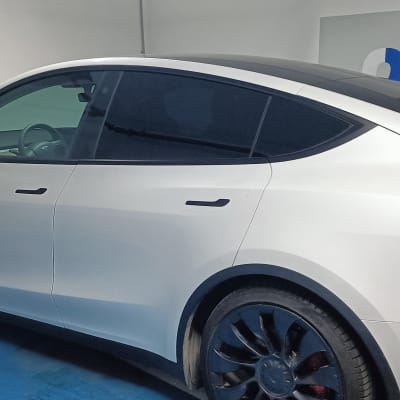 מכונית לבנה עם חלונות כהים בחניון