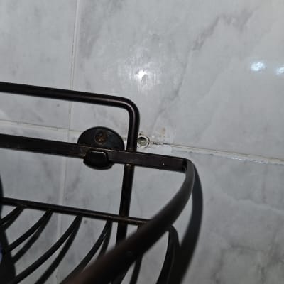 מתלה מתכת על קיר אריחים עם סימני רטיבות