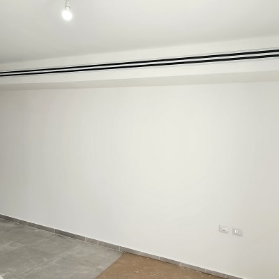 קיר לבן צבוע עם רצפת אריחים אפורה