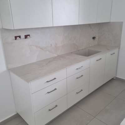 ארונות מטבח לבנים עם משטח עבודה ושיש