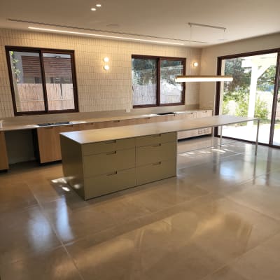 מטבח נקי עם רצפה מבריקה ומשטחי עבודה מסודרים