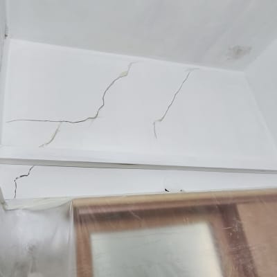 קיר עם סדקים ופלסטיק מכסה חלון