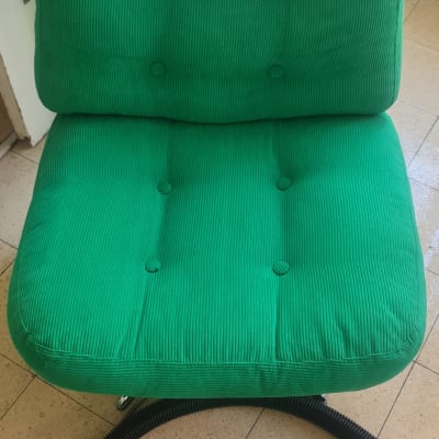 כיסא ירוק עם צינור ניקוי על רצפה