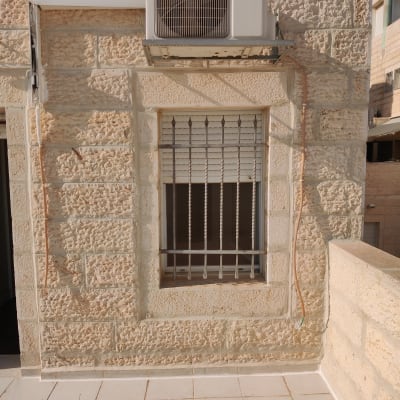 יחידת מיזוג אוויר מותקנת על קיר אבן חיצוני