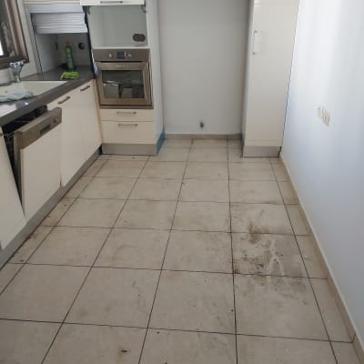 רצפה מלוכלכת במטבח עם סימני לכלוך ומים