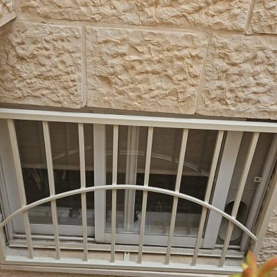 חלון עם סורגים על קיר אבן