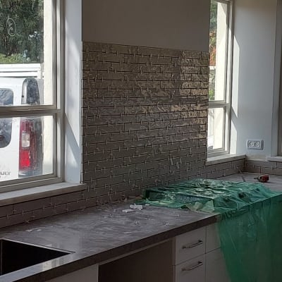 מטבח בשיפוץ עם אריחים חדשים על הקיר