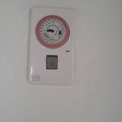 טיימר חשמלי עם כפתור הפעלה על קיר