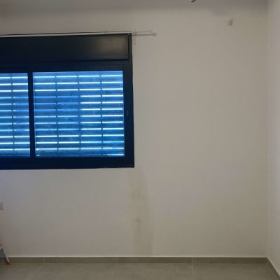 חלון עם תריסים סגורים בחדר מואר