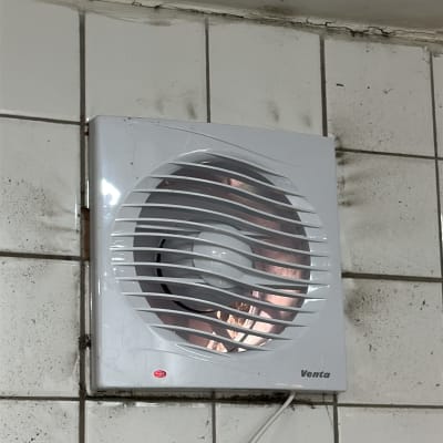 מאוורר מותקן על קיר עם אריחים