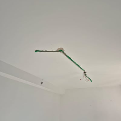 חוטי חשמל חשופים בתקרה עם סולם עץ