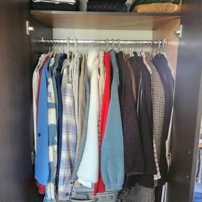 ארון בגדים מסודר עם בגדים מקופלים ומזוודות