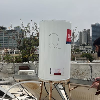 דוד שמש על גג עם צינורות ומתקן חלוד