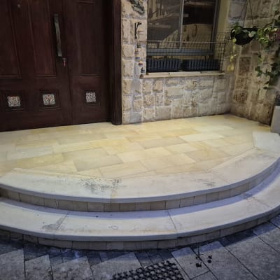 מדרגות אבן עם לכלוך קל ליד דלת עץ