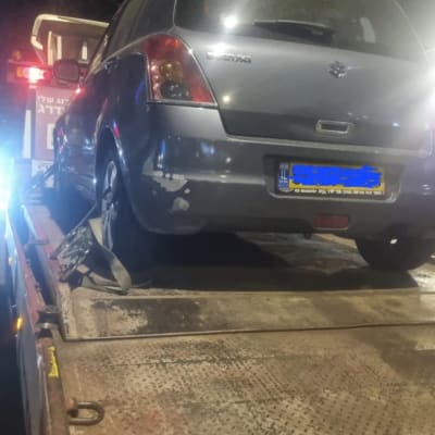 מכונית על גרר עם רצועות קשירה