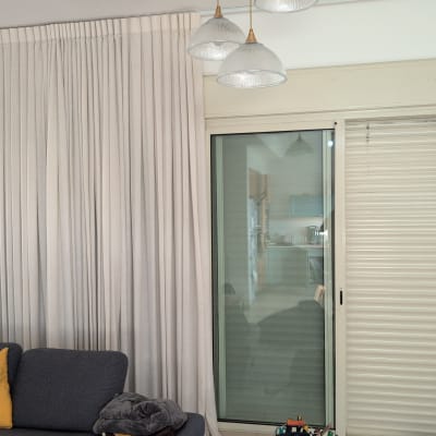 סלון עם וילון ותריסים סגורים ליד חלון זכוכית