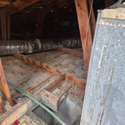 עבודת ניקוי בעליית גג עם צינור ומרסס