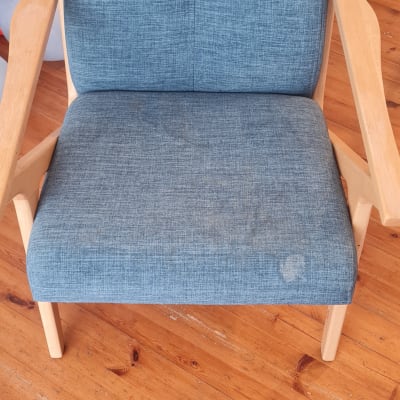 כיסא כחול עם כתמים על רצפת עץ