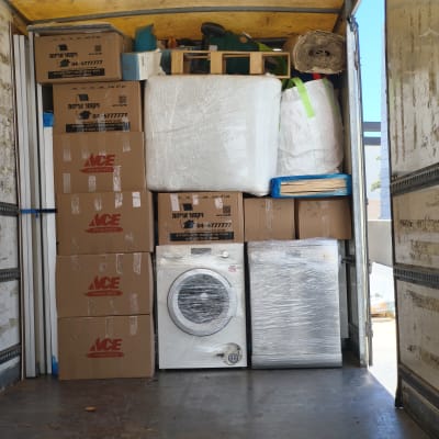 משאית עם קרטונים ומכשירי חשמל להובלה