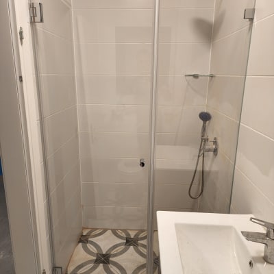 מקלחת עם ראש גשם ודלת זכוכית שקופה