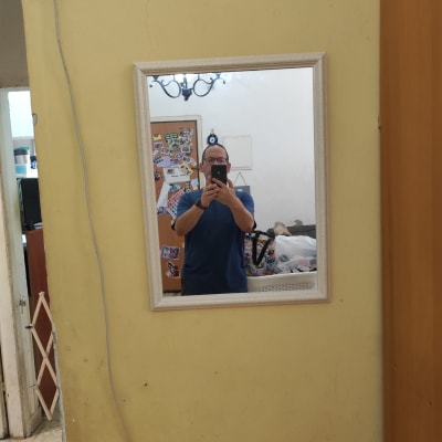 אדם מצלם מראה על קיר עם כבל חשמל תלוי