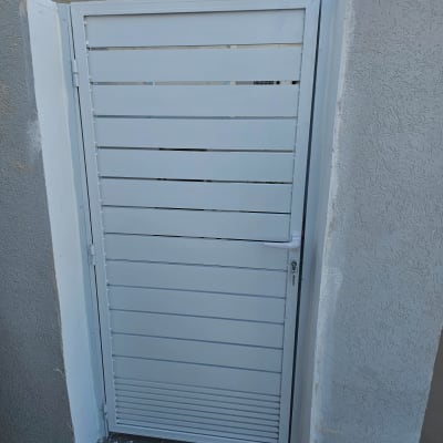 שער אלומיניום לבן בין קירות בטון