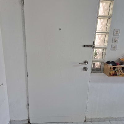 דלת לבנה עם ידית מתכת ובריח