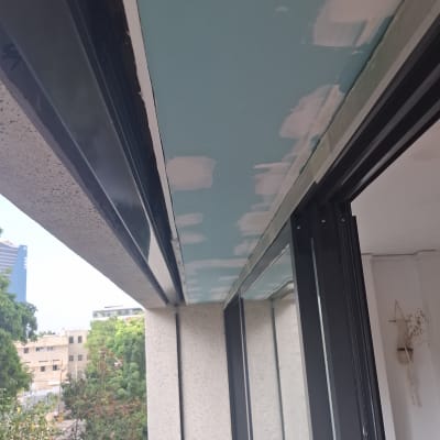 התקנת תקרת גבס ירוק במרפסת בשלב מריחת שפכטל