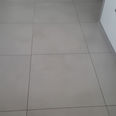 רצפת אריחים אפורה עם ארונות לבנים ברקע