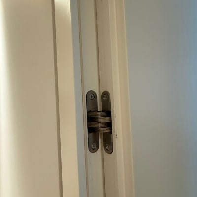 ציר דלת מתכת מותקן על דלת לבנה