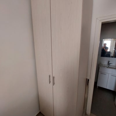 ארון עץ עם ידיות מתכת בחדר