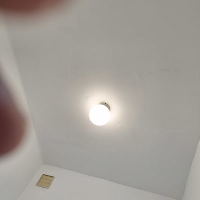 תקרה צבועה בלבן עם מנורה עגולה