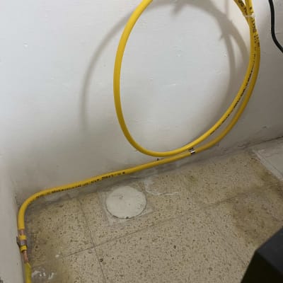 צינור גז צהוב מותקן על קיר לבן