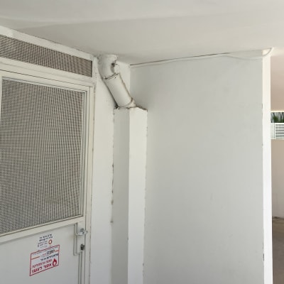 דלת מתכת עם רשת, צינור לבן על קיר