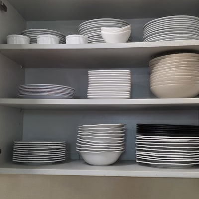 מדפים עם צלחות מסודרות בארון מטבח