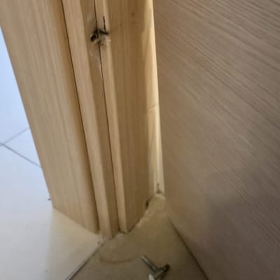 חלק תחתון של דלת עם מסגרת עץ וברגים על הרצפה