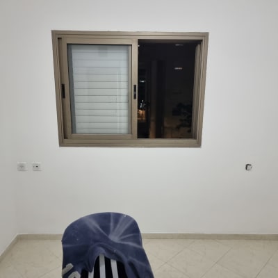 קיר צבוע לבן עם חלון ומתגי חשמל