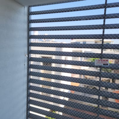 רשת מתכת על חלון למניעת כניסת יונים