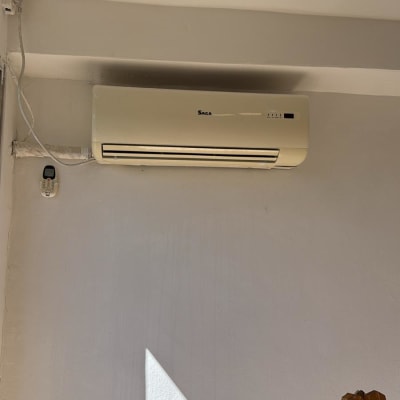 מזגן מותקן על קיר עם שלט רחוק תלוי