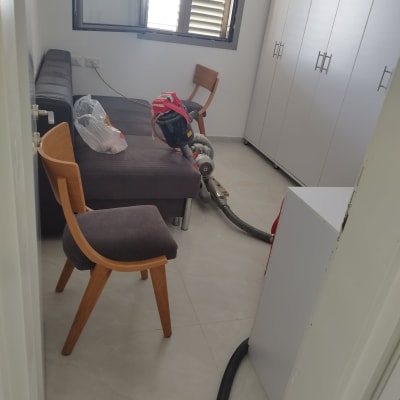 חדר עם ספה, כיסאות, וציוד ייבוש על הרצפה