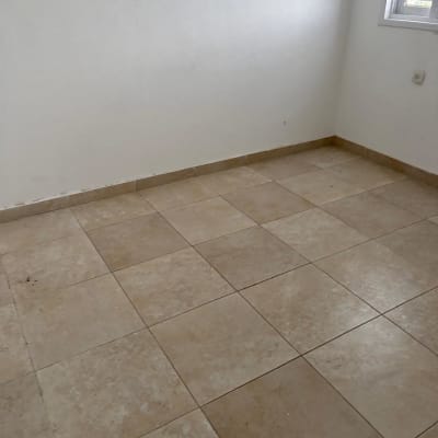 חדר ריק עם רצפת אריחים וקיר לבן