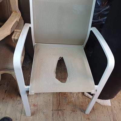 כיסא עם ריפוד קרוע במושב על רצפת עץ