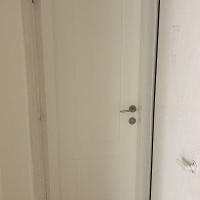 דלת לבנה מותקנת עם ידית כסופה