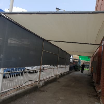 סוכך בד מתוח על מסגרת מתכת לאורך שביל