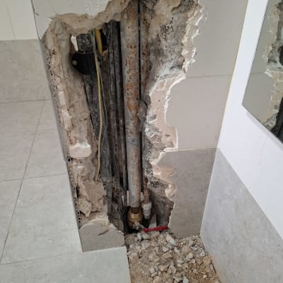 צנרת חשופה בקיר עם שסתום וברז אדום