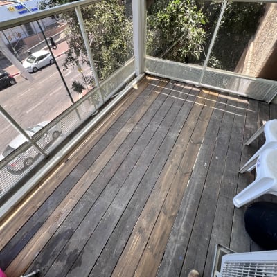 מרפסת עץ עם כיסאות פלסטיק וכלי עבודה צהוב