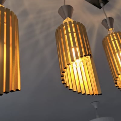 שלושה גופי תאורה תלויים עם נורות דולקות