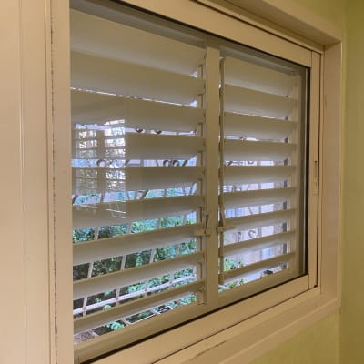 חלון עם תריסים לבנים לניקוי