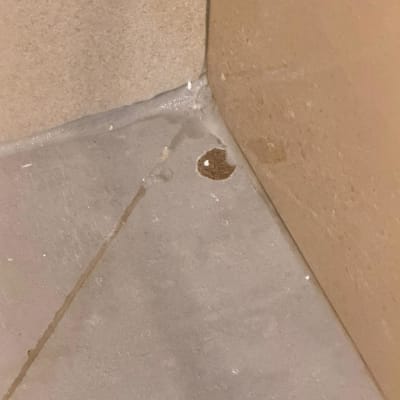 תקריב של פגם וחור באריח ריצוף סמוך לקיר